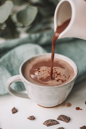 Hot chocolate being poured into a china cup